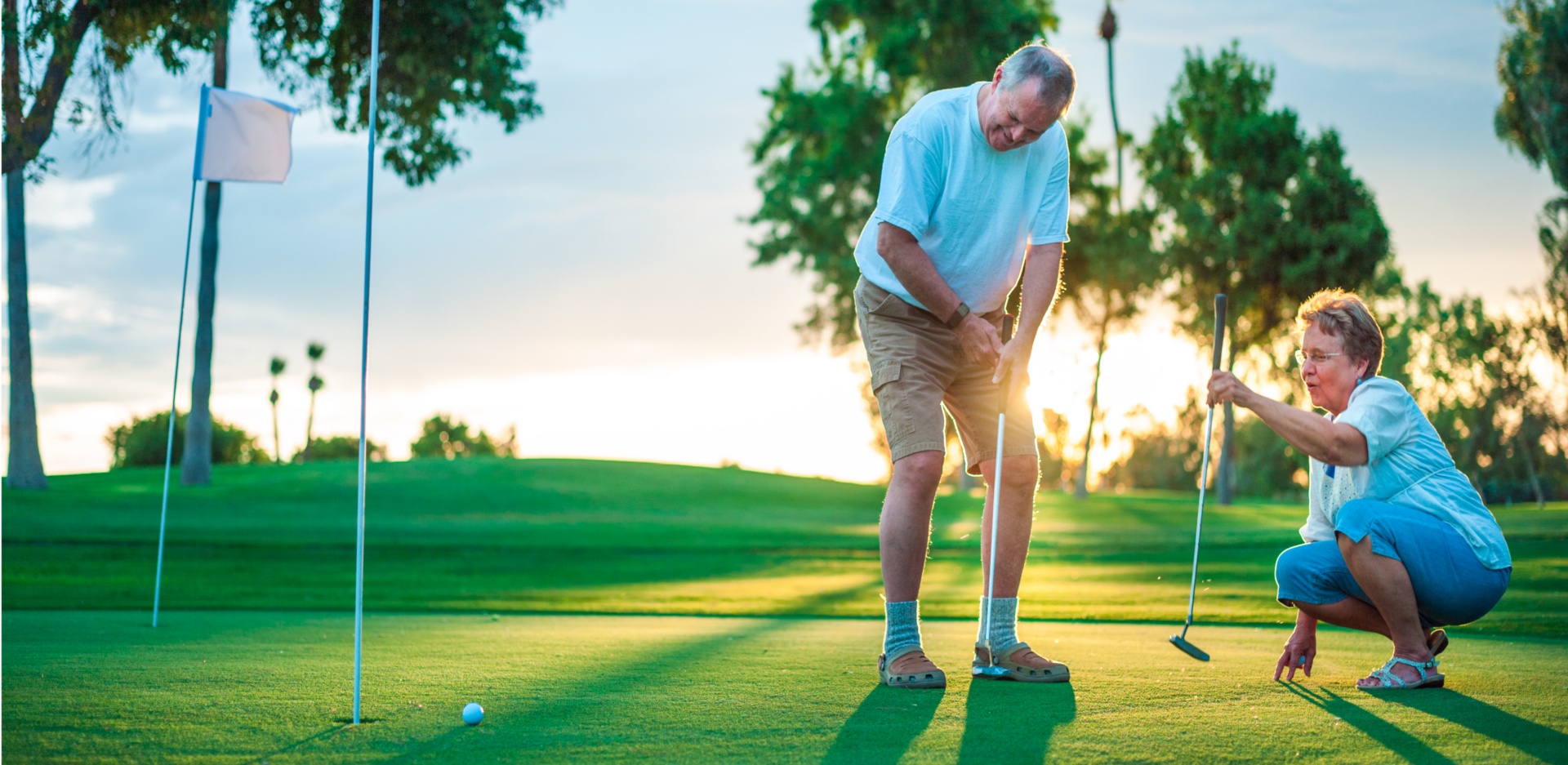 Senior couple playing golf on a sunny day