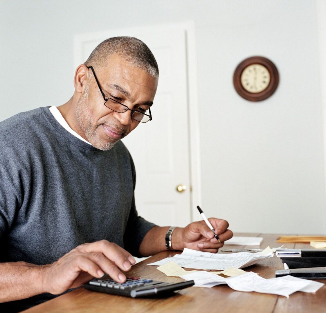 Man calculating expenses with calculator